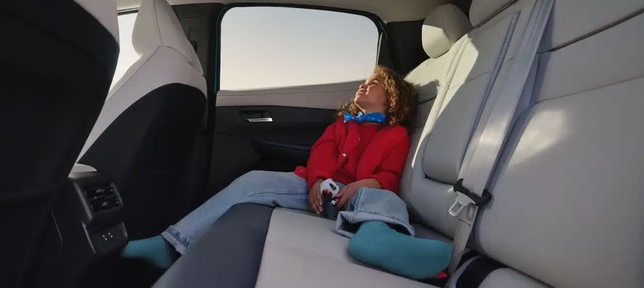 Rückbank eines Nissan LEAF mit entspanntem Kind, geräumiger und heller Innenraum.