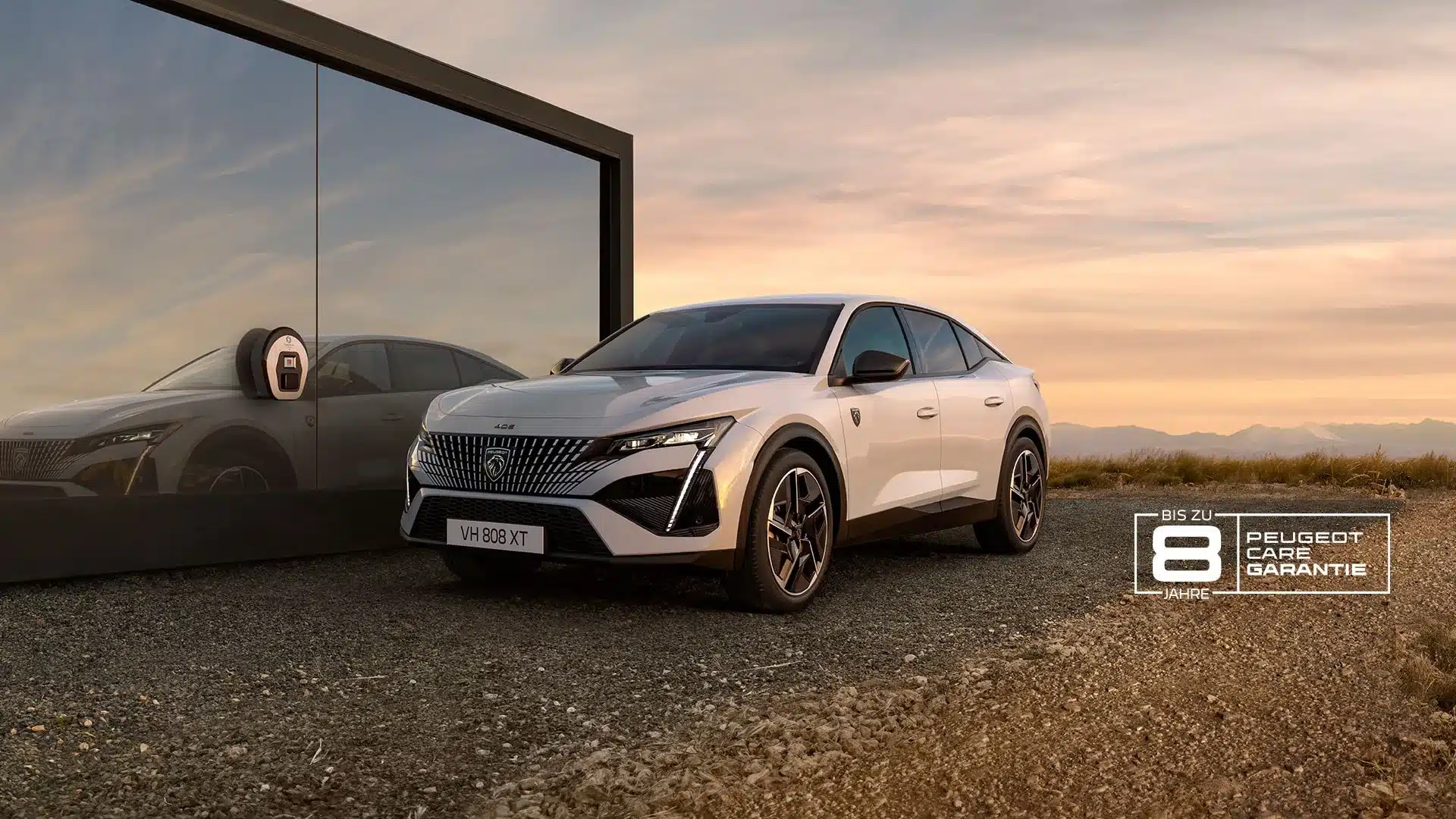 Peugeot E-408 weiß vor einer Glasfassade an einer Ladestation bei Sonnenuntergang