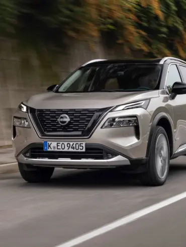 Neuer Nissan X-Trail e-POWER SUV auf der Straße, Vorderansicht, mit EP-NCAP-5-Sterne-Test-Siegel.