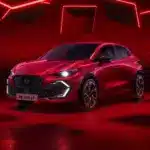 Roter Renault Clio Full Hybrid E-Tech 2026 vor rotem Hintergrund mit LED-Lichtakzenten.