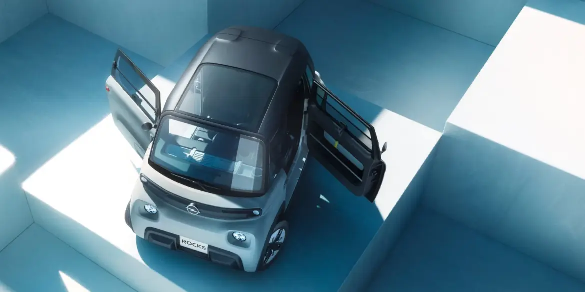 Opel Rocks-e Elektroauto von oben mit beiden gegenläufig öffnenden Türen, in urbaner Umgebung