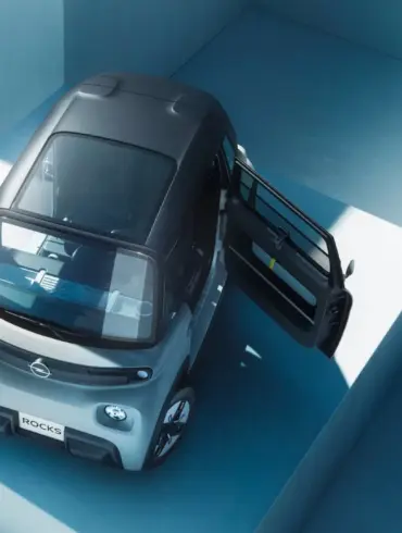 Opel Rocks-e Elektroauto von oben mit beiden gegenläufig öffnenden Türen, in urbaner Umgebung