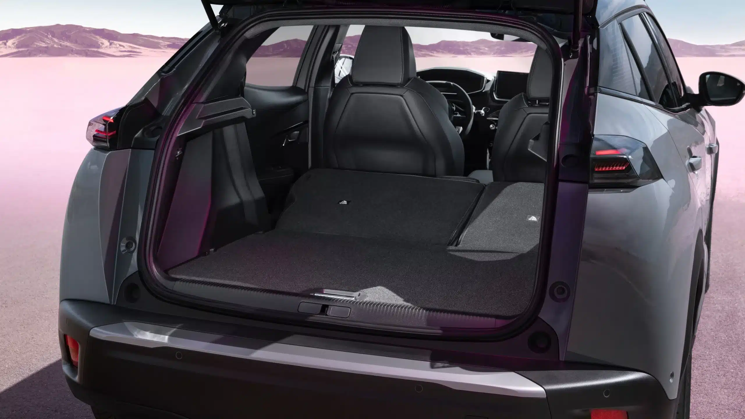 Blick in den offenen Kofferraum eines Peugeot 2008 mit umgeklappter Rückbank, um das maximale Ladevolumen zu zeigen.