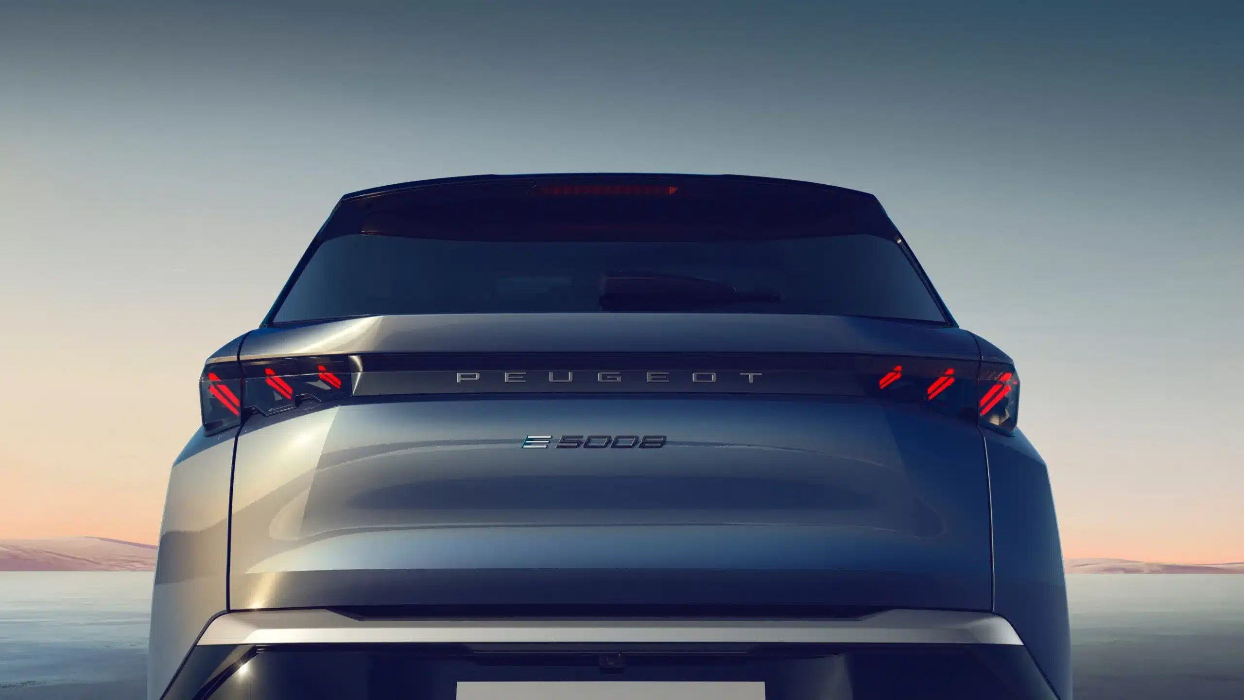 Heckansicht eines Peugeot 5008 Hybrid mit markanten LED-Rückleuchten und Modellschriftzug bei Sonnenuntergang.