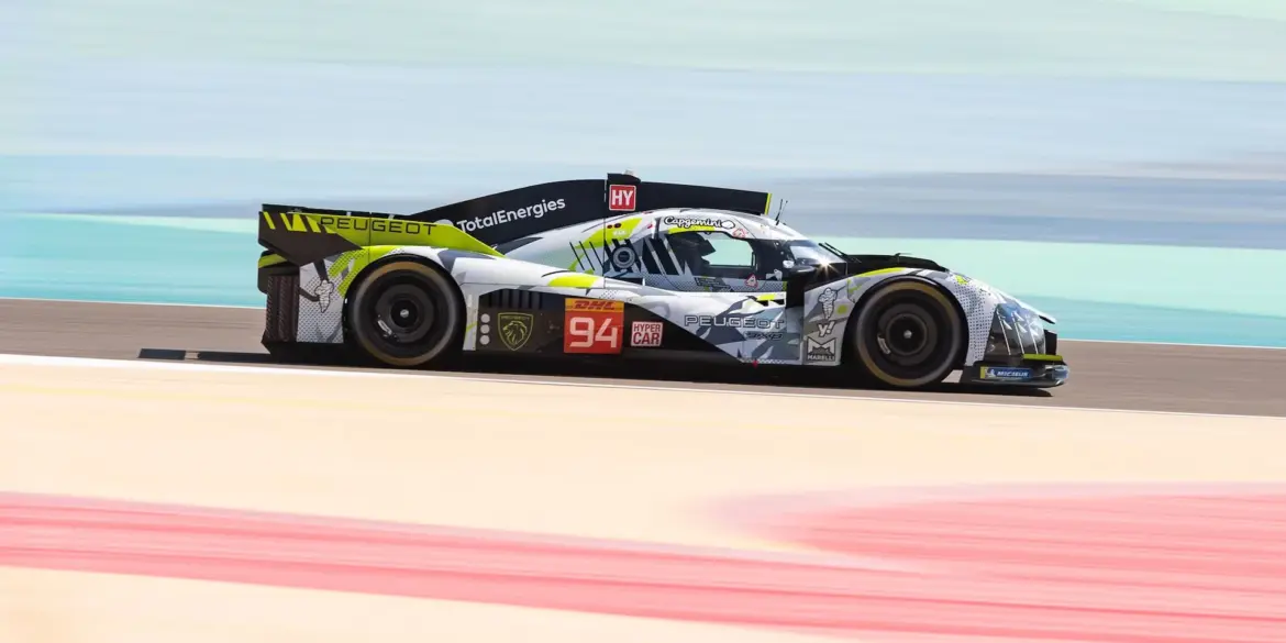 Peugeot 9X8 Hypercar auf der Rennstrecke mit auffälliger Art-Car-Lackierung in Grau, Gelbgrün und Schwarz, seitlich aufgenommen.