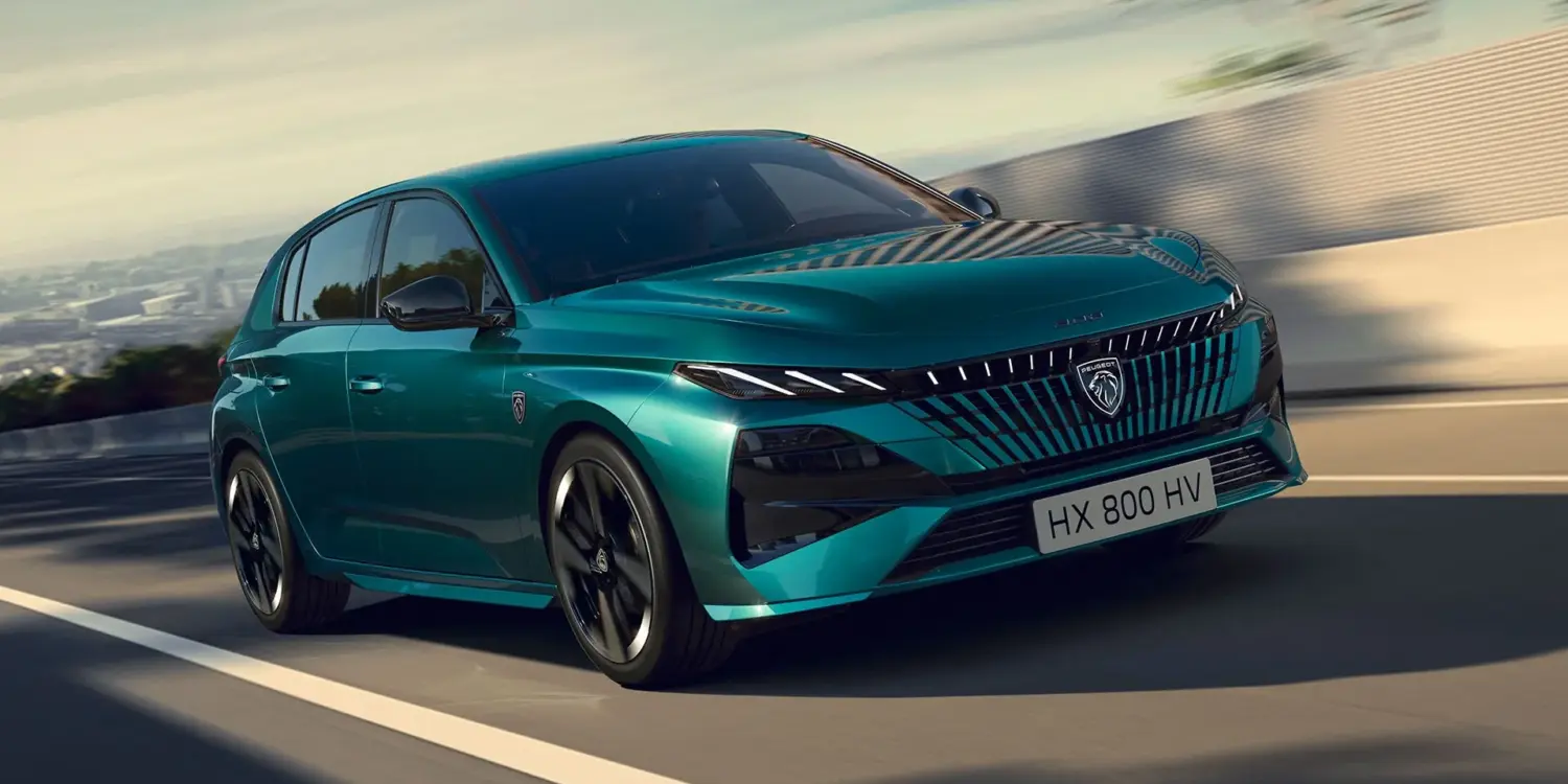 PEUGEOT E-308 in Türkis, frontal aufgenommen auf einer Landstraße.