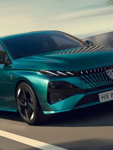 PEUGEOT E-308 in Türkis, frontal aufgenommen auf einer Landstraße.