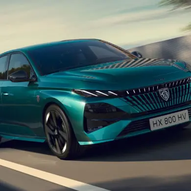 PEUGEOT E-308 in Türkis, frontal aufgenommen auf einer Landstraße.