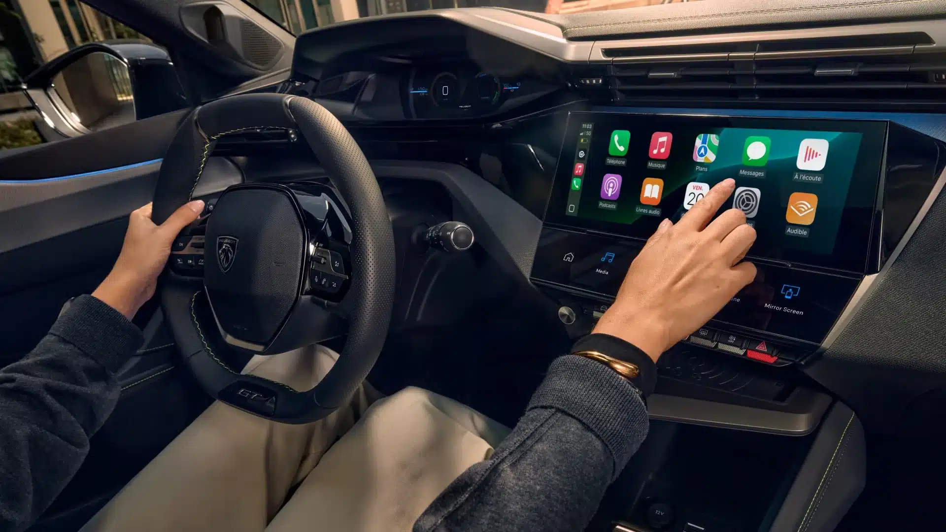 Blick auf das PEUGEOT E-308 i-Cockpit mit Lenkrad und großem Infotainment-Touchscreen, der Apple CarPlay zeigt.