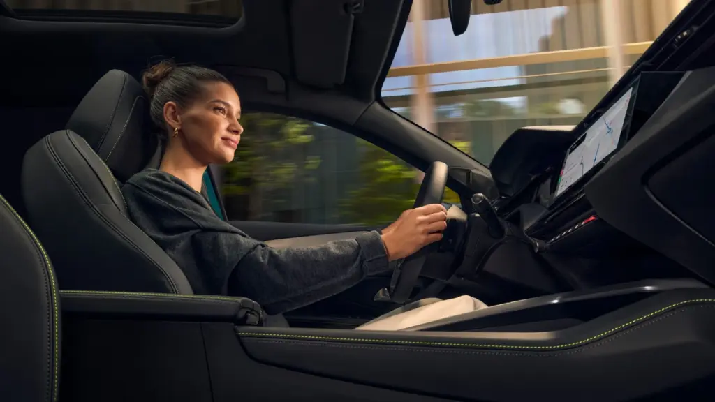 Innenraum des PEUGEOT E-308 mit einer Frau am Steuer und Blick auf das digitale Cockpit