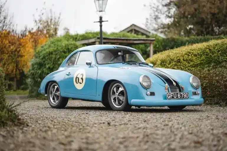 Blauer Porsche 356 Outlaw Tribute mit schwarzen Rennstreifen und Startnummer 63, fotografiert im Freien auf einem Kiesweg.