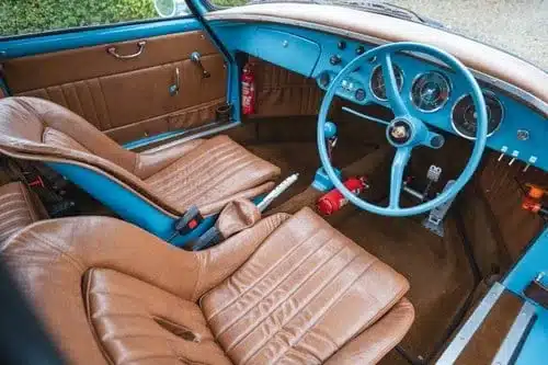 Blauer Porsche 356 Outlaw Tribute mit Tan-Leder-Innenraum, Lenkrad links, klassische Instrumente und hochwertige Verarbeitung.