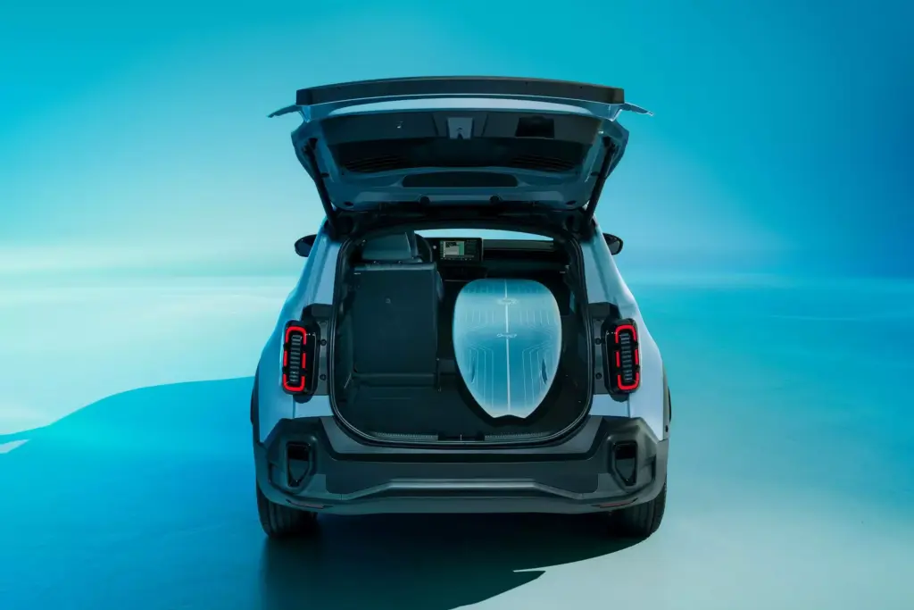 Heckansicht des Renault 4 E-Tech Électrique mit geöffnetem Kofferraum und Surfbrett