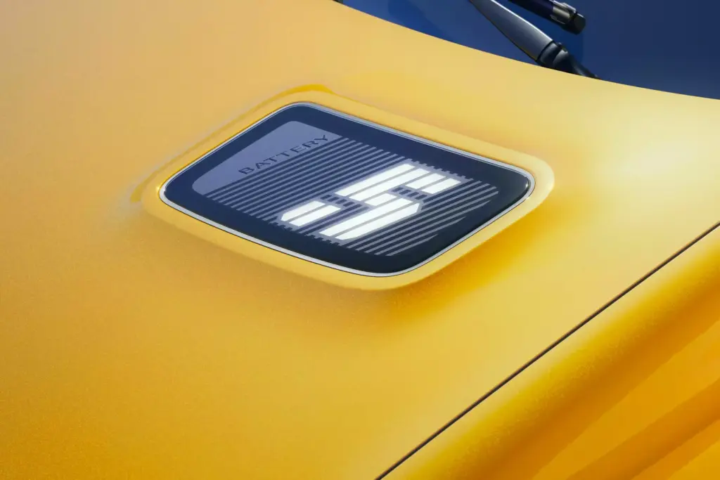 Detailaufnahme des leuchtenden '5'-Logos auf der Motorhaube des Renault 5 E-Tech Electric in Gelb.