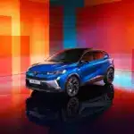 Renault Captur E-Tech Hybrid in Blau auf Hochglanzboden vor abstraktem, farbenfrohem Hintergrund.