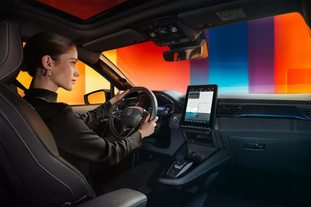 Fahrerin im Innenraum eines Renault Captur E-Tech Hybrid mit großem Display und moderner Ausstattung