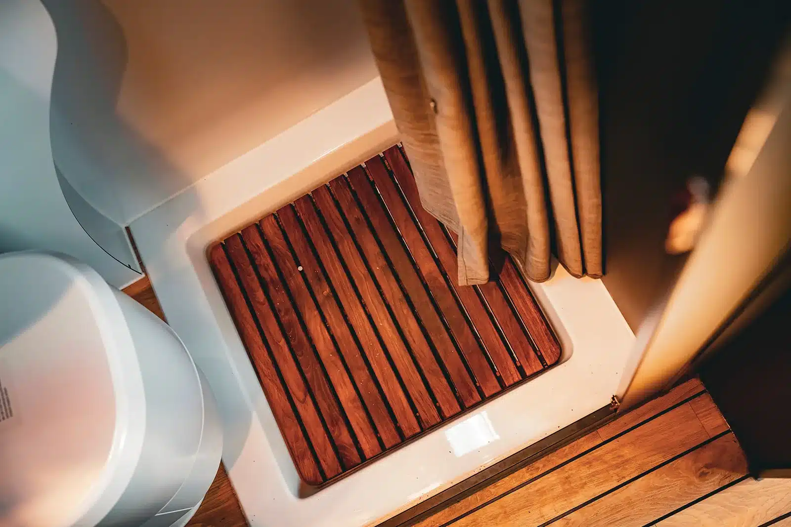 Teak-Einlage in der Duschwanne des Renault Master VANtastic mit Vorhang und Toilettenelement