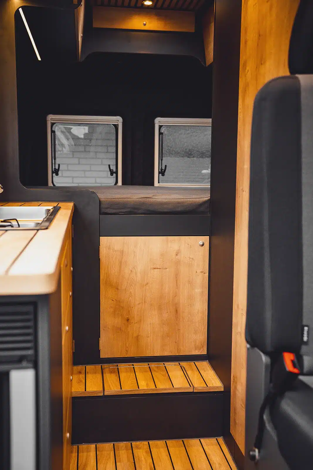 Moderne Camper-Innenraumansicht mit Küchenzeile und Heckbett im Renault Master VANtastic