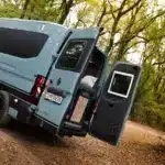 Renault Master VANtastic mit geöffneten Hecktüren und Blick ins Innenraumkonzept des Campers im Wald