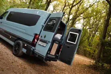 Renault Master VANtastic mit geöffneten Hecktüren und Blick ins Innenraumkonzept des Campers im Wald