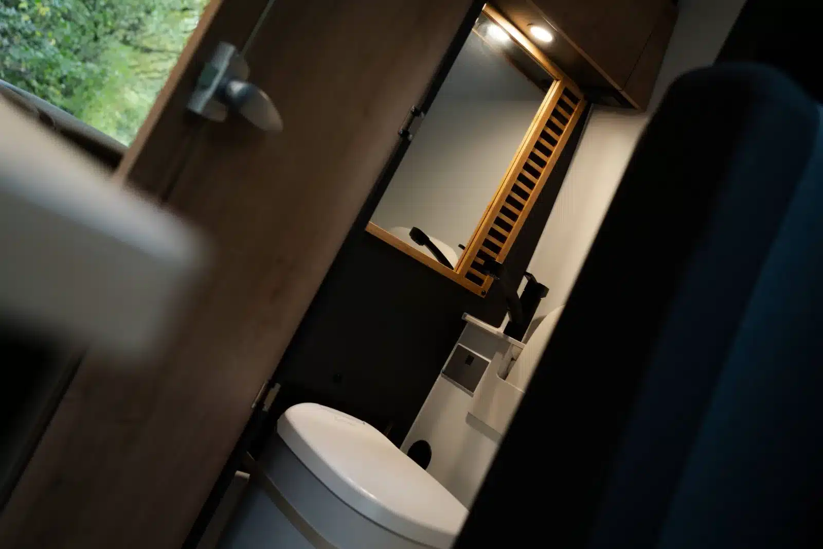 Komfortables Bad mit Clesana-Toilette, Spiegel und Waschbecken im Renault Master VANtastic Campervan