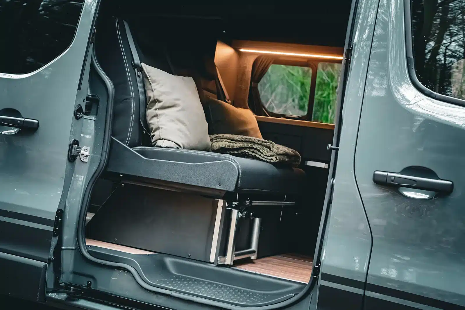 Blick in den Innenraum des Renault Trafic BS-Camp mit moderner Schlafsitzbank und gemütlicher Beleuchtung
