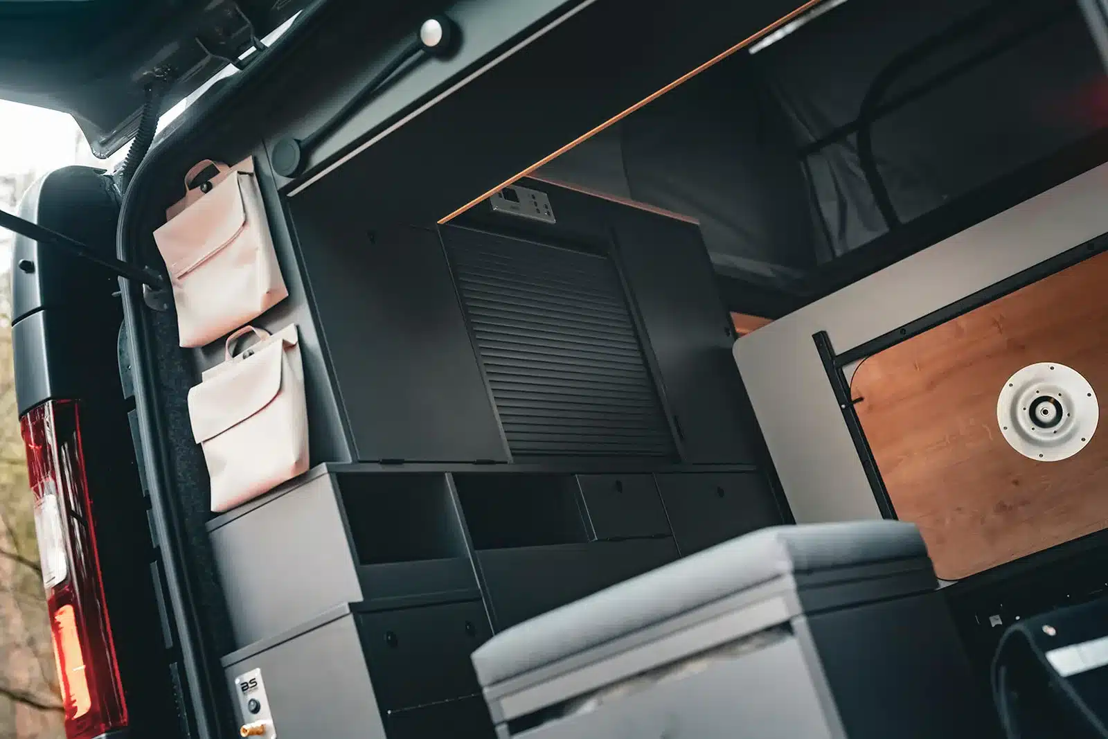 Innenansicht des Renault Trafic BS-Camp mit Stauraum, Schränken und Klapptisch im Heck.