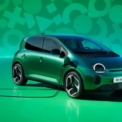 Renault Twingo E-Tech Electric beim Ladevorgang an einer öffentlichen Ladesäule vor grünem Hintergrund
