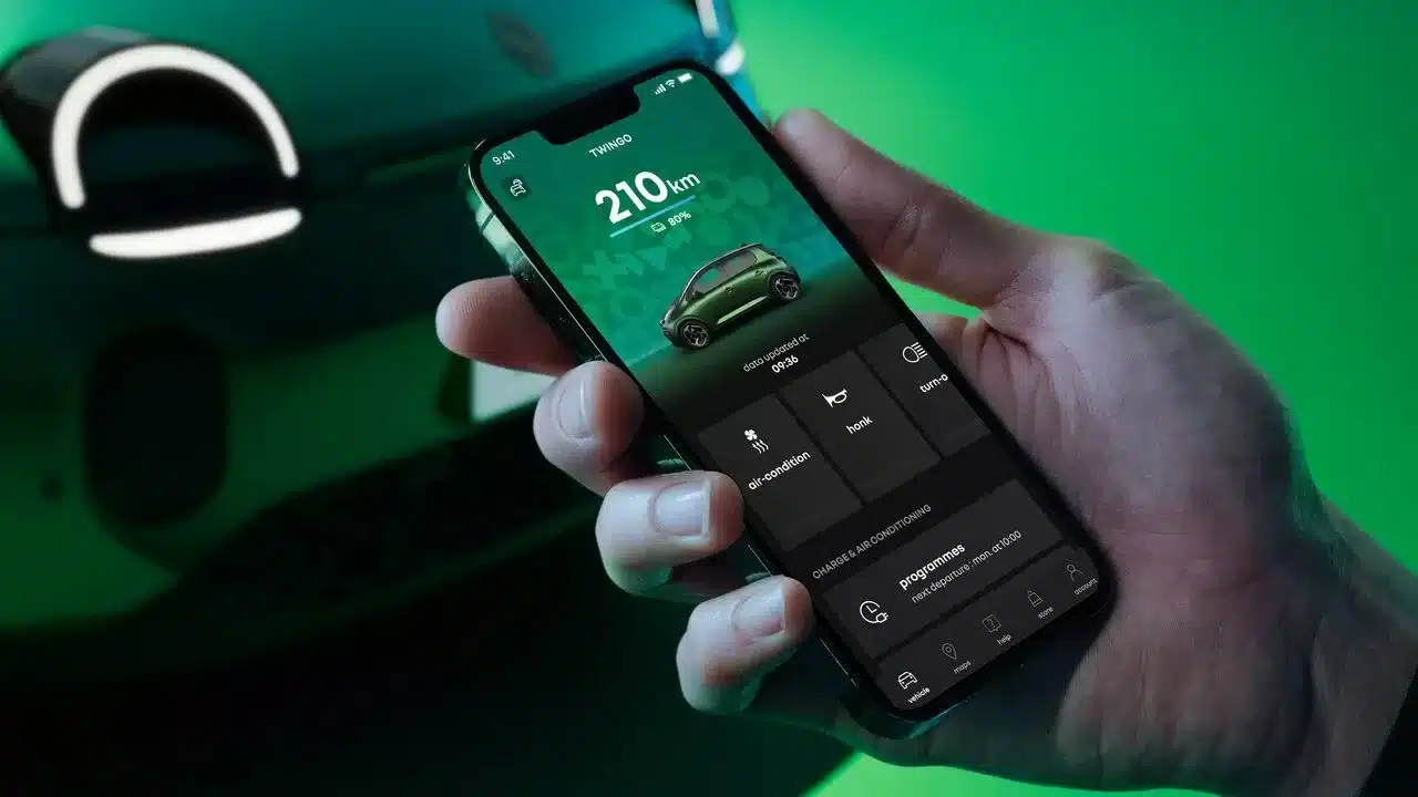 Hand hält Smartphone mit Fernsteuerungs-App und Reichweitenanzeige für Renault Twingo E-Tech Electric