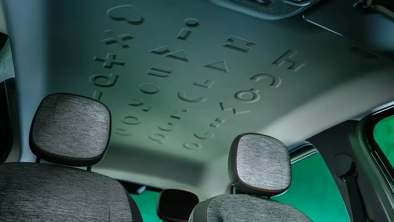 Innenraum des Renault Twingo E-Tech Electric mit geprägten Symbolen am Dachhimmel und modernen Kopfstützen