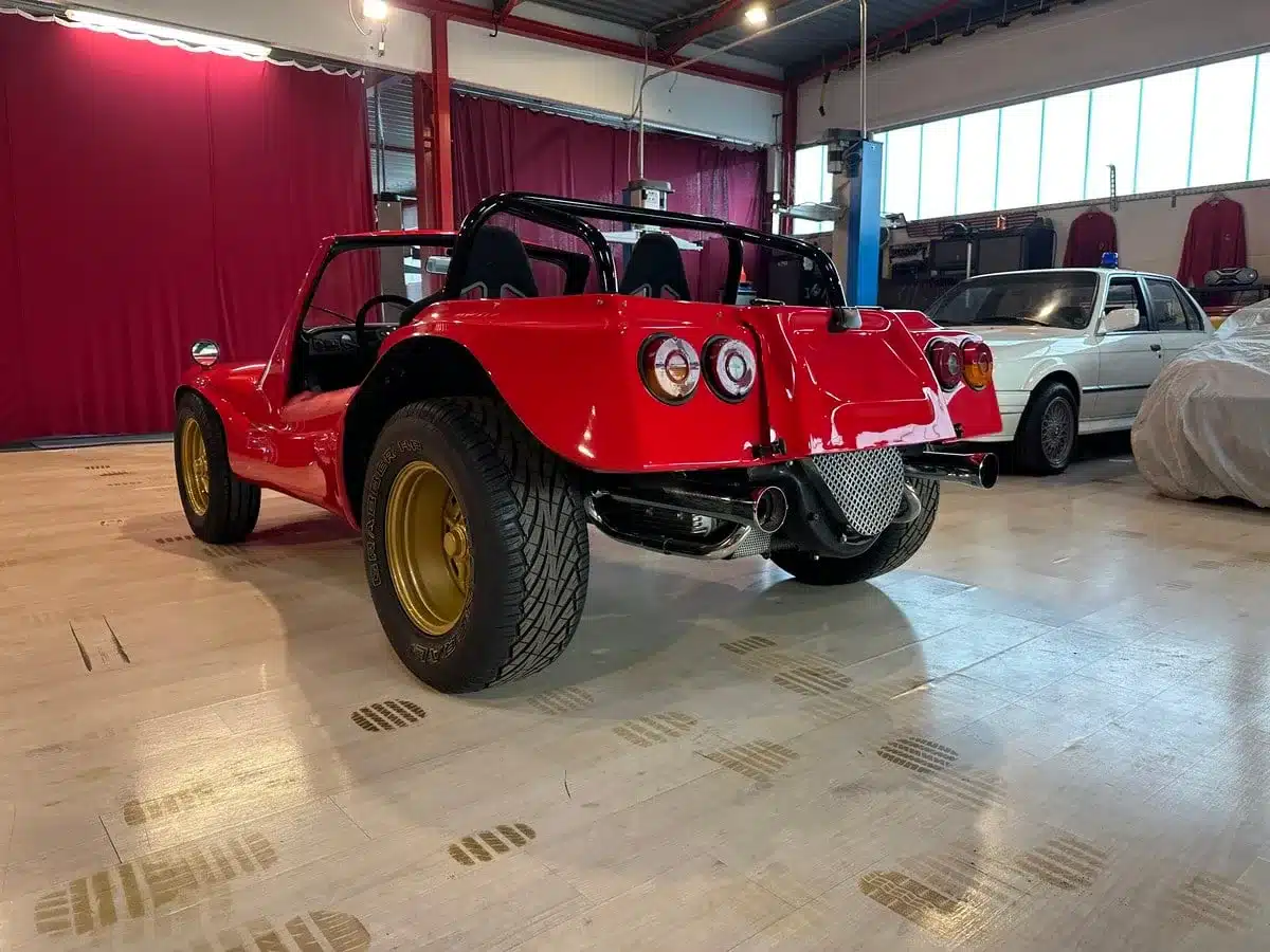 Roter Volkswagen Deserter GT Buggy von 1970 mit goldenen Felgen von hinten in einer Halle