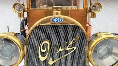 Front eines Opel Oldtimers mit verzierten Messingteilen und markantem Logo