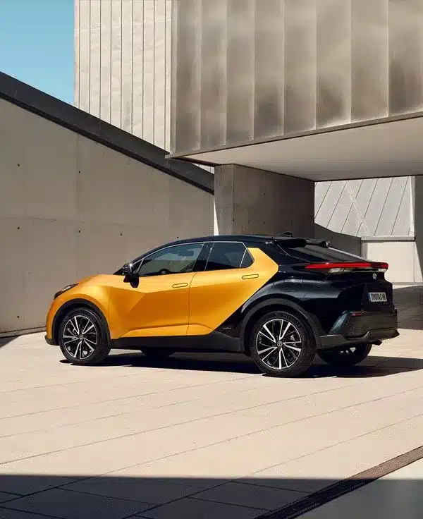 Toyota C-HR Hybrid in gold-schwarz, Seitenansicht in moderner Umgebung