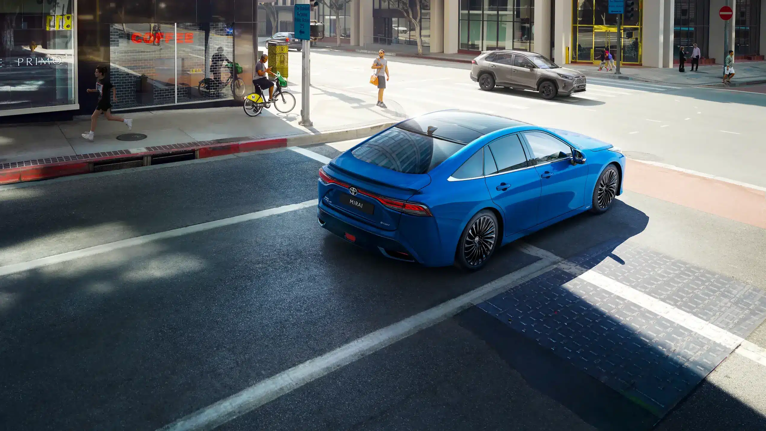 Blauer Toyota Mirai steht an einer Kreuzung in einer Innenstadt, Heckansicht, moderner Straßenverkehr
