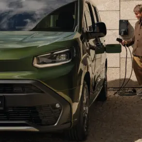 Toyota Proace City Verso in grün beim Laden an einer Wandladestation