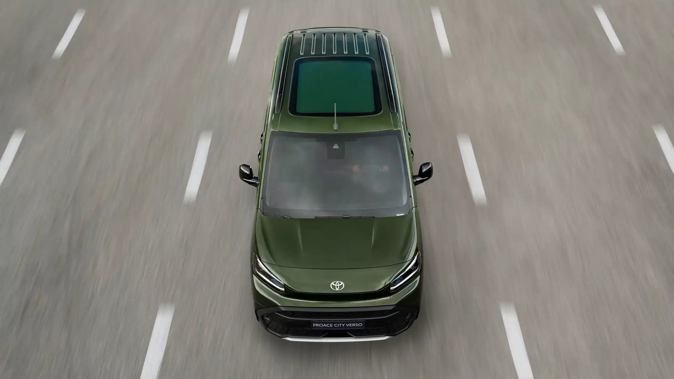 Toyota Proace City Verso in Grün mit Panorama-Glasdach, aus der Vogelperspektive auf der Straße fotografiert.