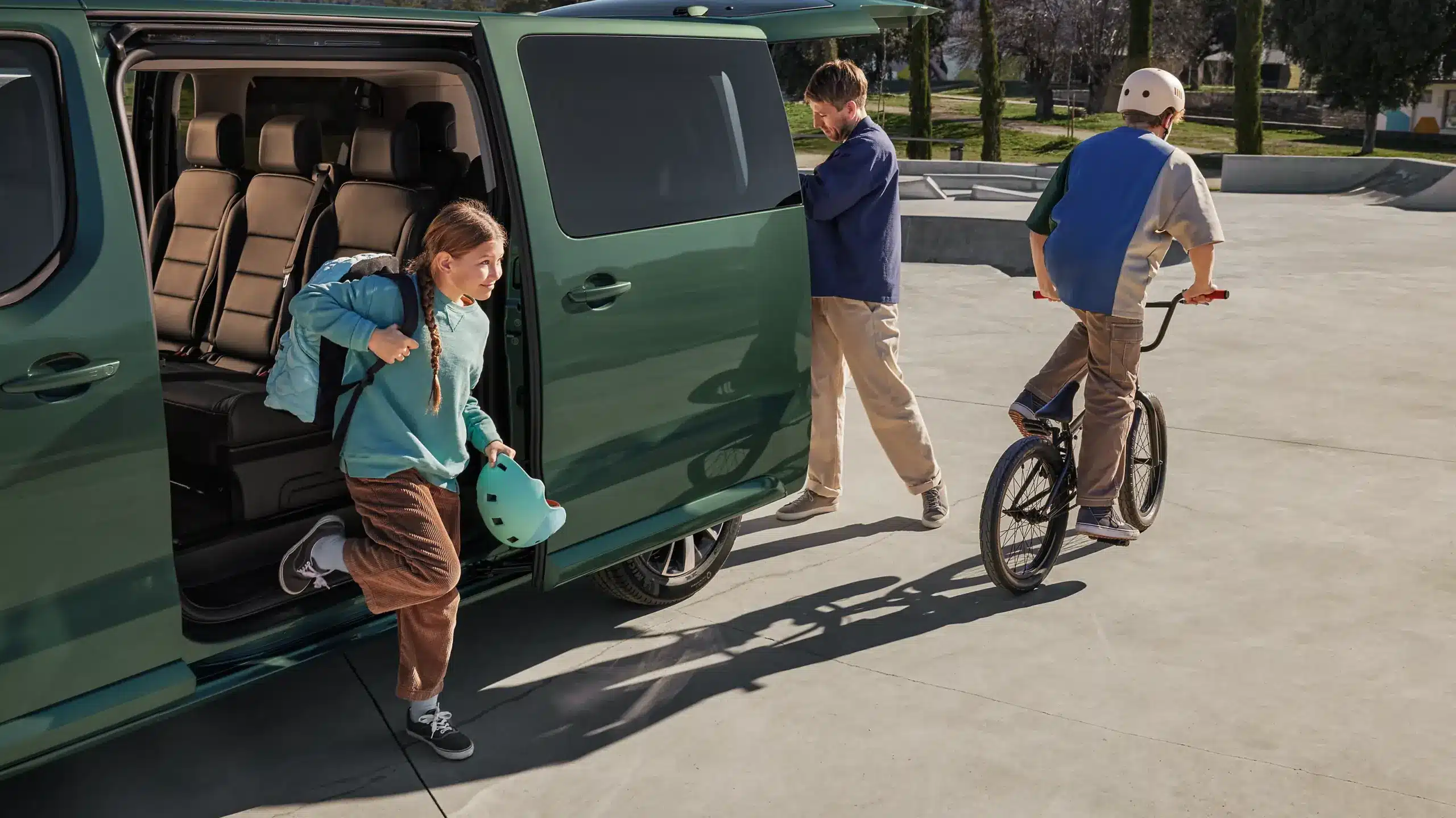 Toyota Proace Verso mit geöffneter Schiebetür, während Kinder und ein Erwachsener das Fahrzeug beim Ausflug verlassen.