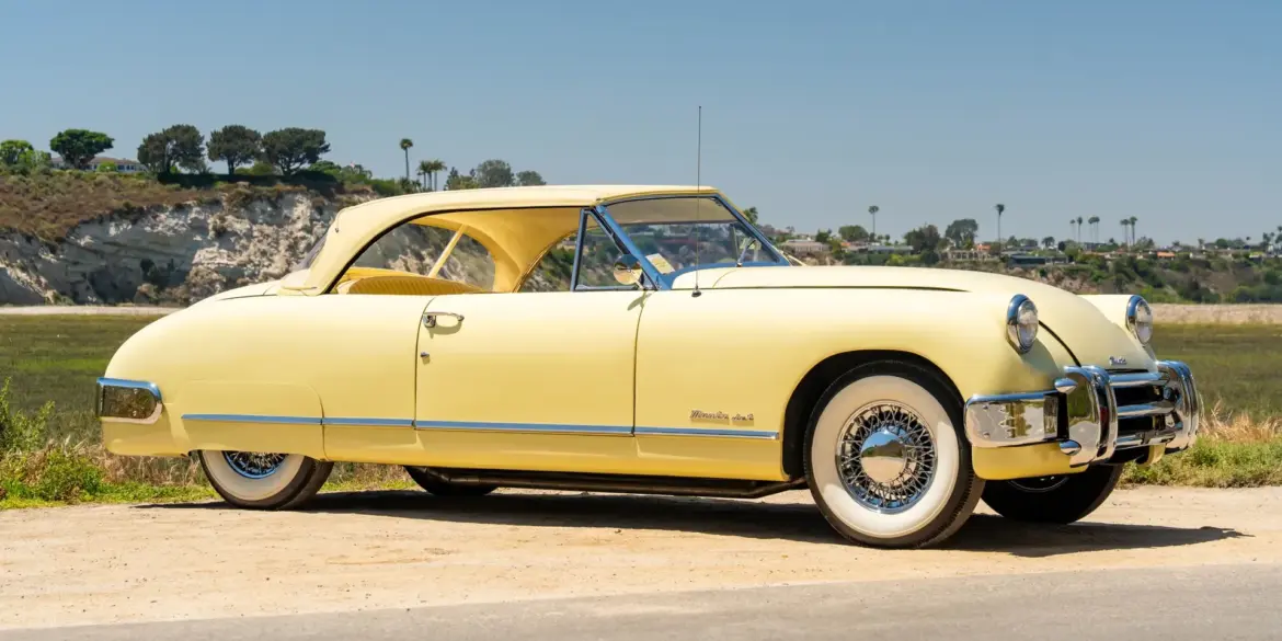 Seitenansicht eines gelben 1952 Muntz Jet Cabriolets vor natürlicher Kulisse