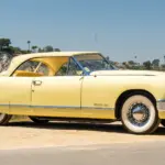 Seitenansicht eines gelben 1952 Muntz Jet Cabriolets vor natürlicher Kulisse