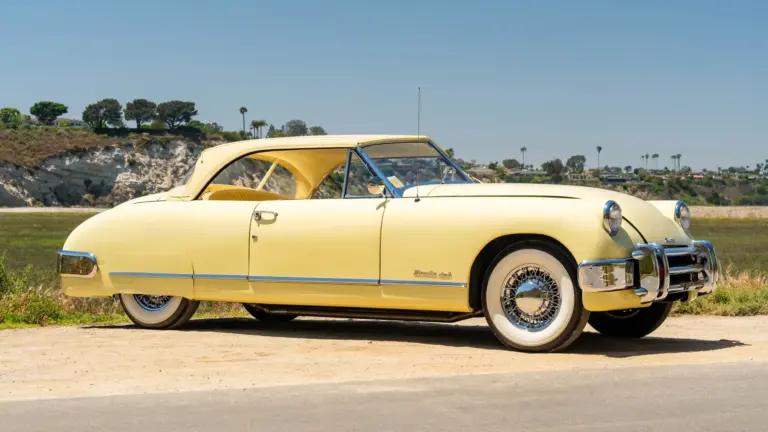 Seitenansicht eines gelben 1952 Muntz Jet Cabriolets vor natürlicher Kulisse