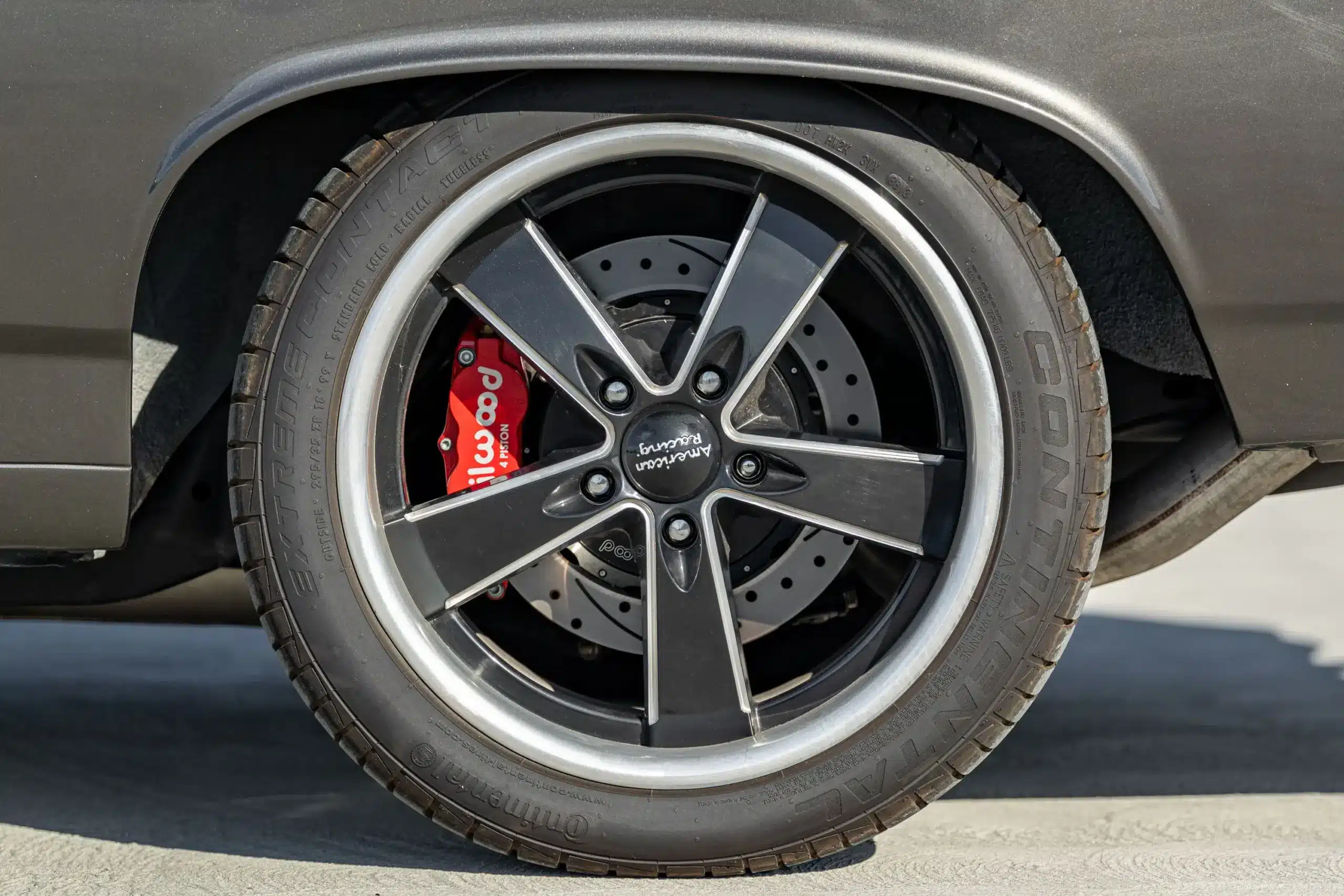 Nahaufnahme eines schwarzen Alufelgenrads mit Continental-Reifen und Wilwood-Bremsanlage an einem klassischen Chevrolet Chevelle Malibu