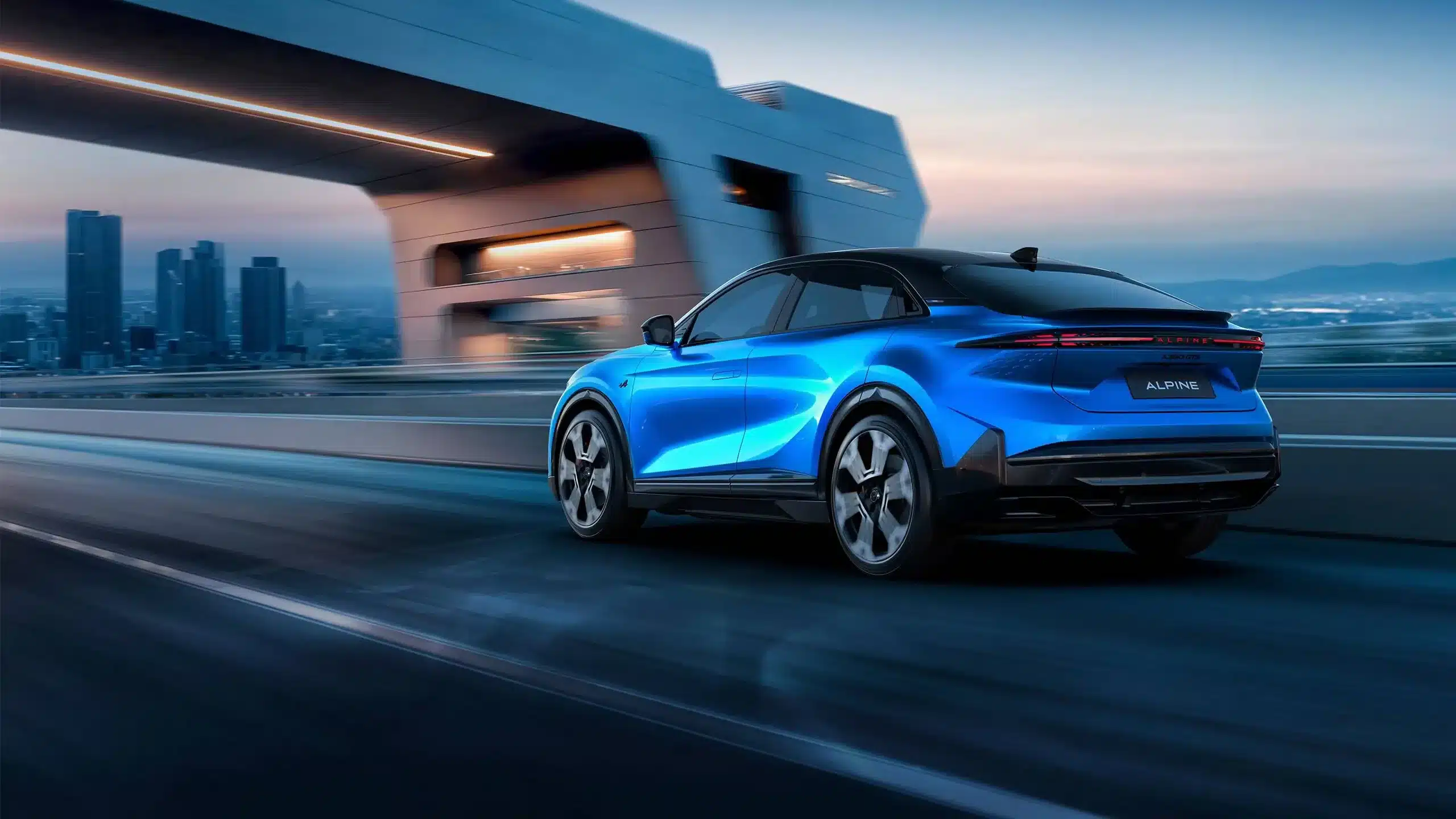 Der Alpine A390 in Blau fährt auf einer modernen Straße vor urbaner Kulisse.