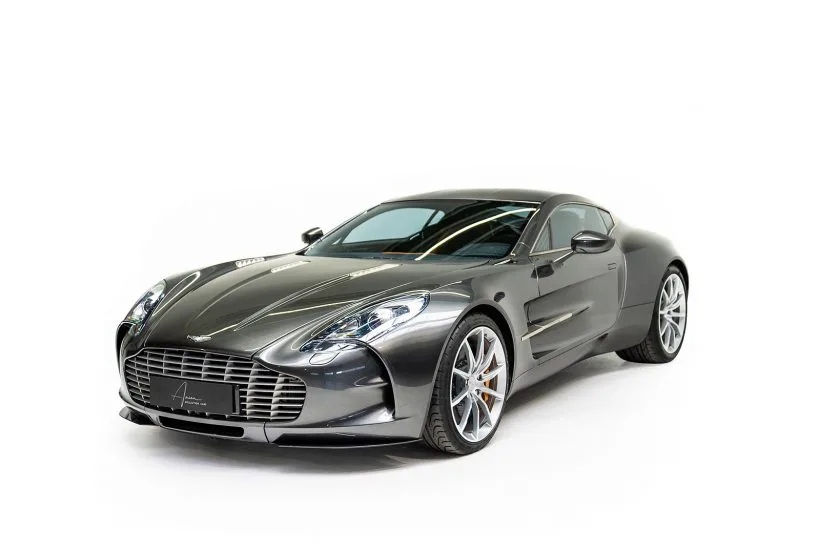 Silberner Aston Martin One-77 im Studio auf weißem Hintergrund, Front- und Seitenansicht.