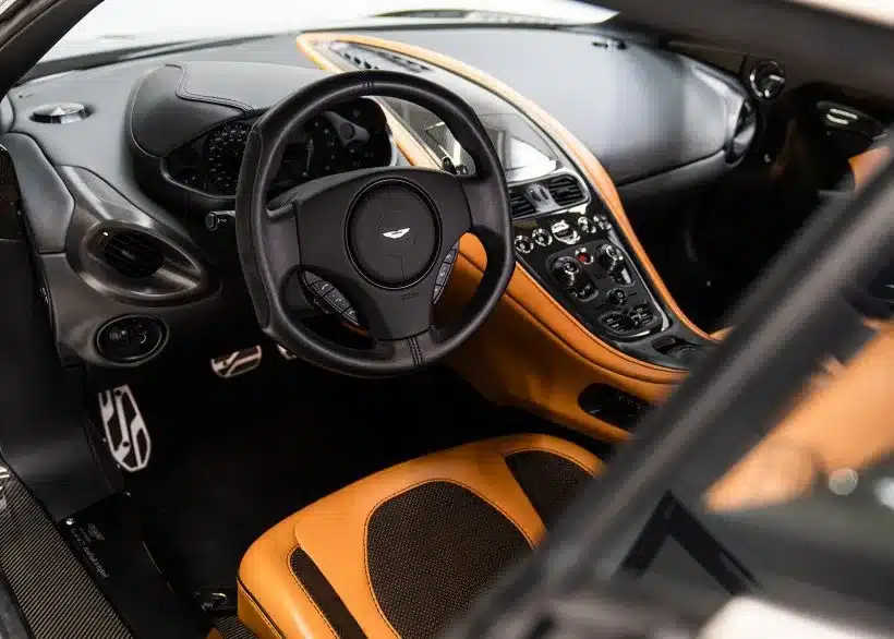 Innenraum des Aston Martin One-77 mit Lenkrad und Mittelkonsole, hochwertige Lederausstattung und Carbon-Details.