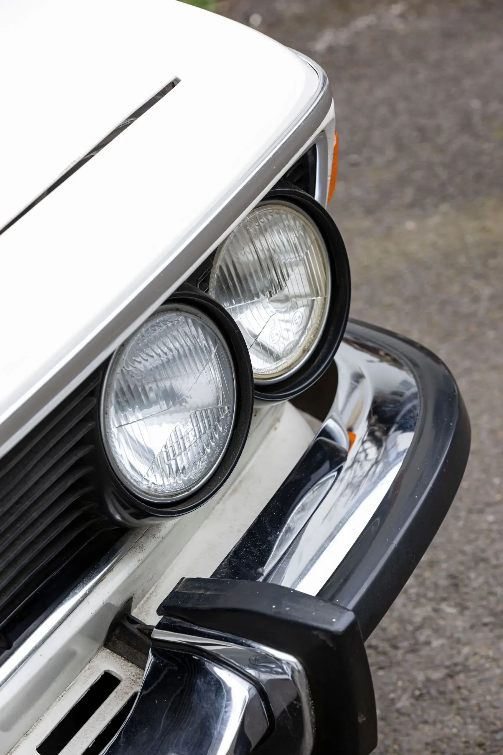 Nahaufnahme der Frontscheinwerfer und Chromstoßstange eines BMW 3.0 CSL von 1973