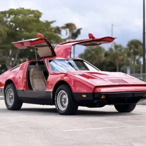 Bricklin SV-1, rotes Sportcoupé von 1975 mit offenen Flügeltüren auf einem Parkplatz, Seitenansicht.