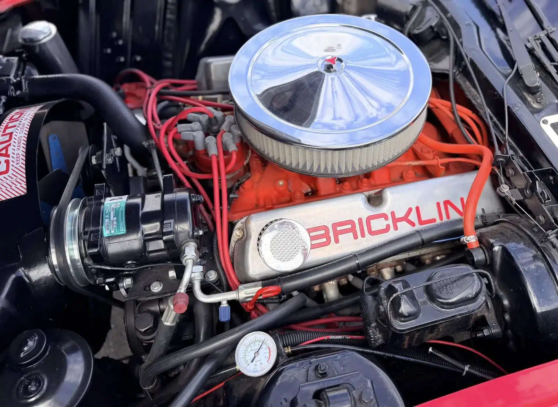 Motorraum eines Bricklin SV-1 von 1975 mit sichtbarem 351-CI-V8-Motor und Bricklin-Schriftzug auf dem Ventildeckel.