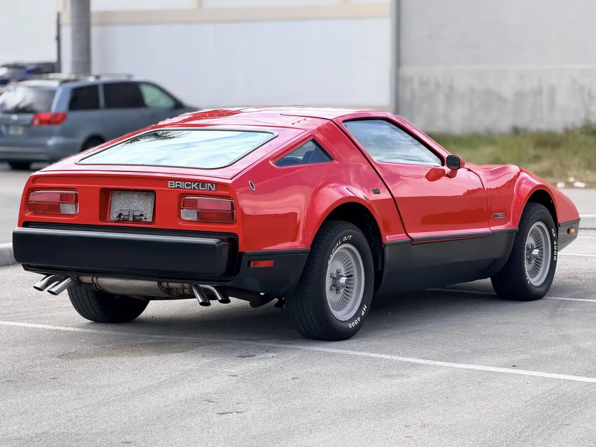 Heckansicht eines roten Bricklin SV-1 von 1975 auf einem Parkplatz.