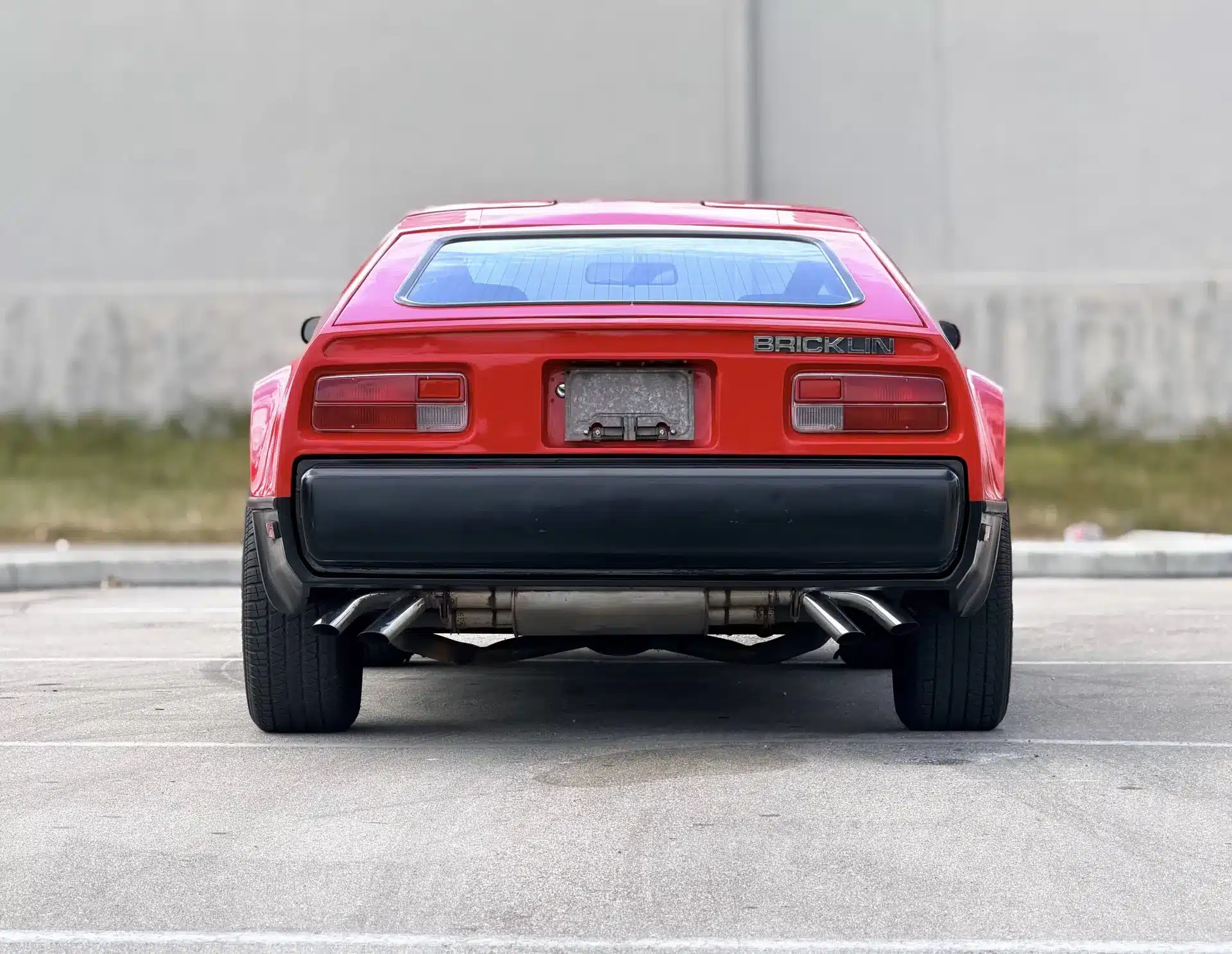 Heckansicht eines roten Bricklin SV-1 aus dem Jahr 1975 auf einem Parkplatz