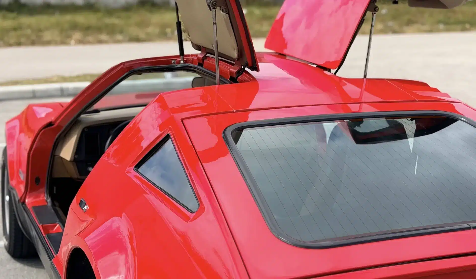 Roter Bricklin SV-1 mit geöffneten Flügeltüren, Ansicht von schräg hinten rechts.